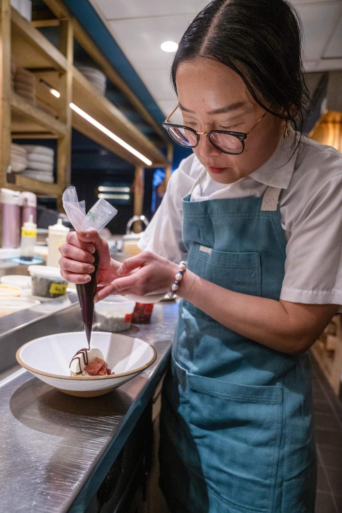 Executive Pastry Chef Helen Jo Leach of The Town Company, who has been nominated for a James Beard award, makes finishes off a Black Sesame Almond Cake with red wine poached pears and yogurt ice cream. The item is a staple on the menu for the James Beard nominated chef.
