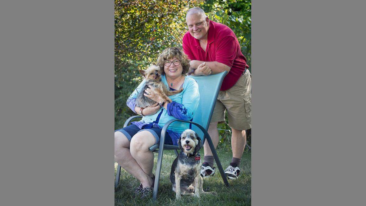 Toby and Chris Dorr with their dogs Tic Tac Toe and Checkers outside their home in Kansas City.