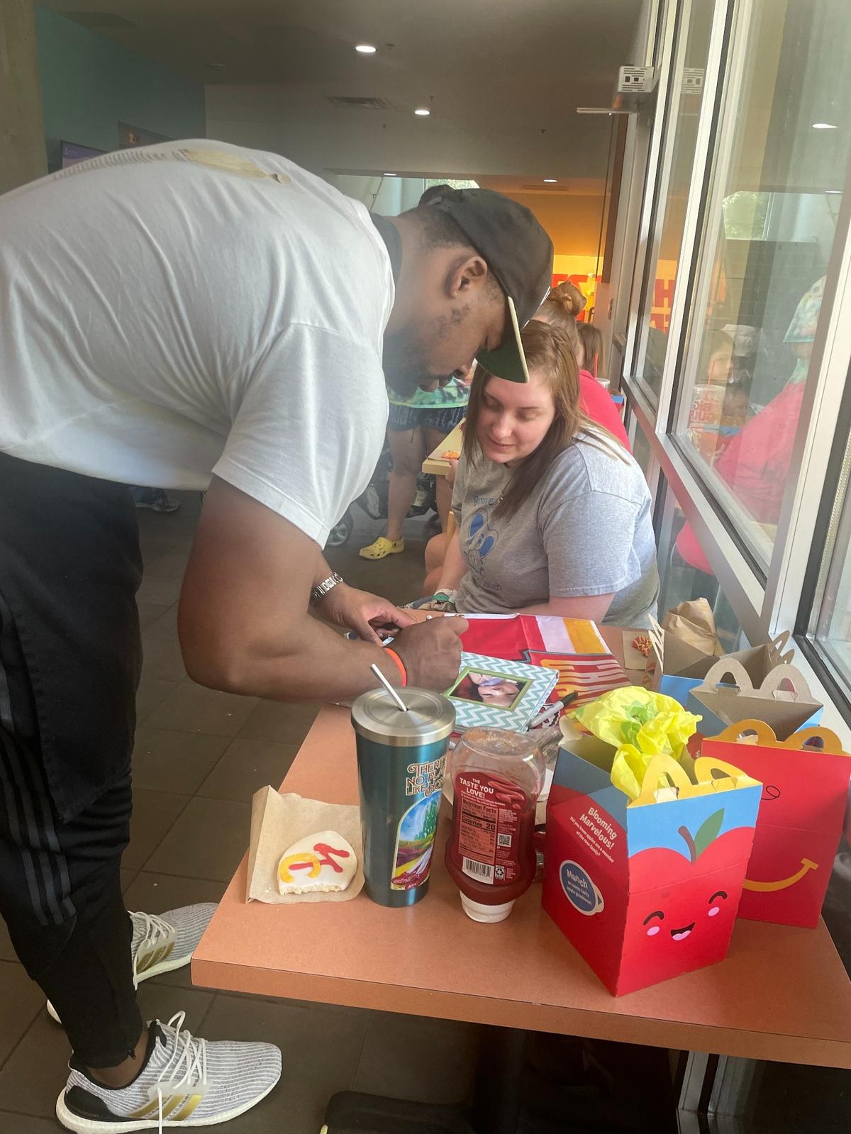 Chiefs defensive tackle Chris Jones signed his autograph for Madison Morris on a picture book of her son, Kingston.
