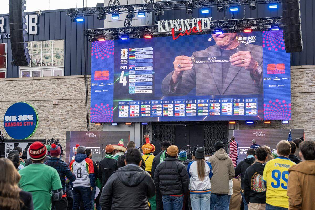 Fans watch the World Cup draw on a big screen during a watch party at the Power & Light District on Friday, Dec. 5, 2025, in Kansas City.
