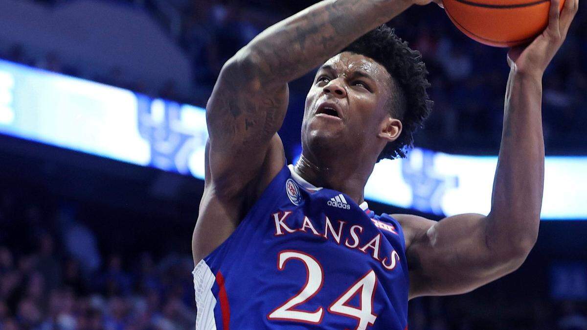 Kansas’ K.J. Adams shoots over Kentucky’s Oscar Tshiebwe during the second half of a game in Lexington, Ky., Saturday, Jan. 28, 2023. Kansas won 77-68.
