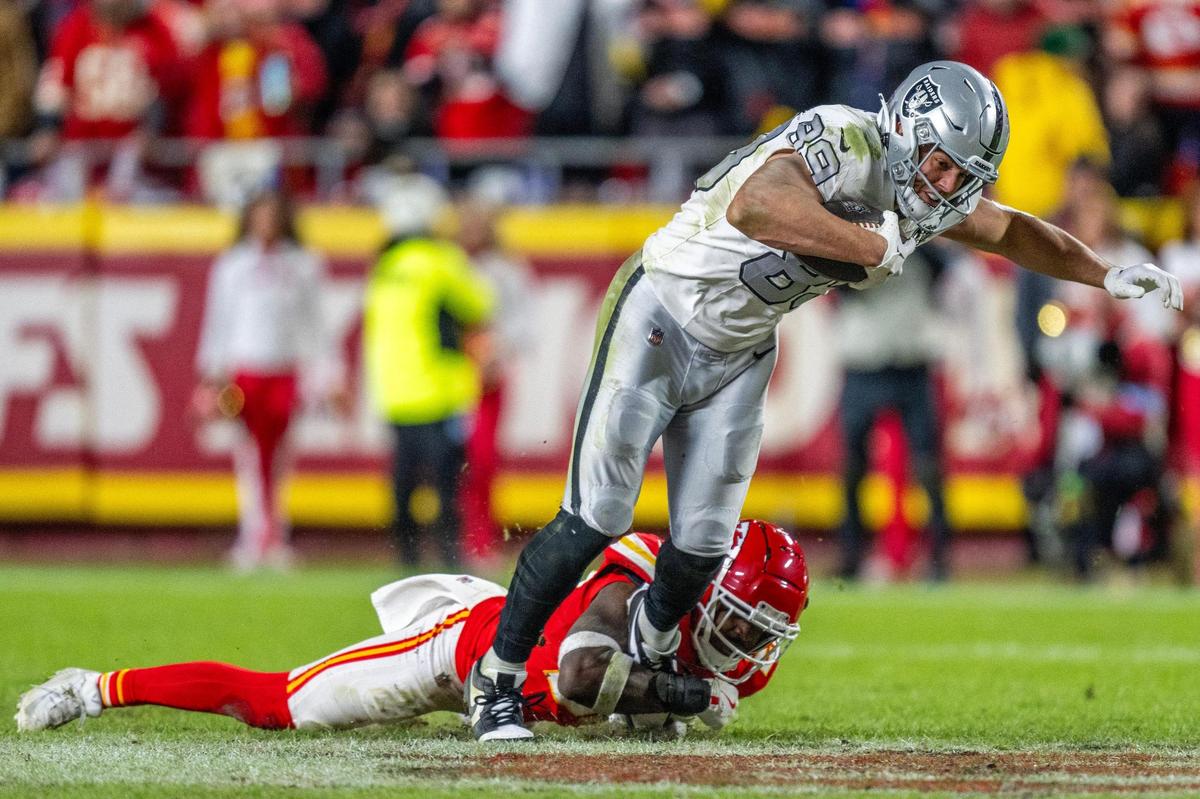 Kansas City Chiefs safety Jaden Hicks (21) tackles Las Vegas Raiders tight end Brock Bowers (89) in the fourth quarter during an NFL game on Friday, Nov. 29, 2024, at GEHA Field at Arrowhead Stadium.