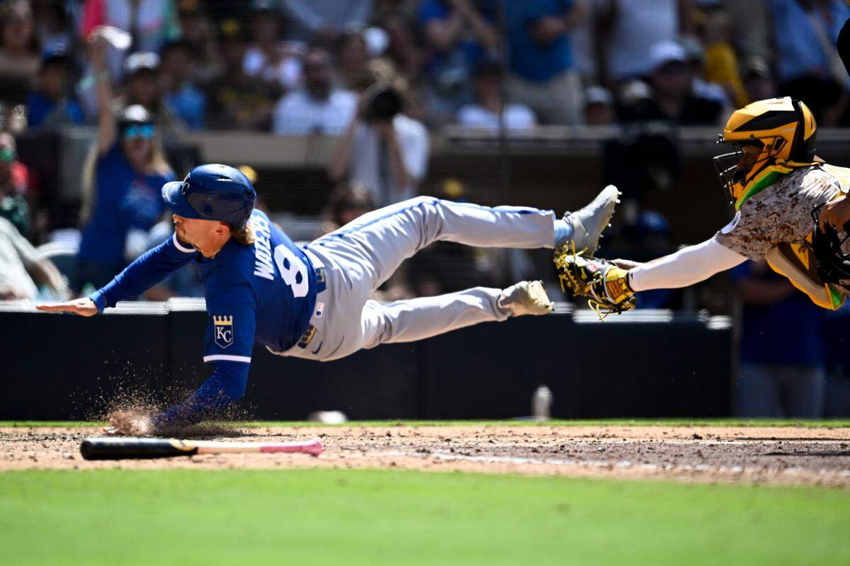 Kansas City Royals outfielder Drew Waters, left, was called out at home plate while trying to score around the tag of Padres catcher Martín Maldonado during the ninth inning of a Sunday, June 22, 2025 Major League Baseball game at Petco Park in San Diego.