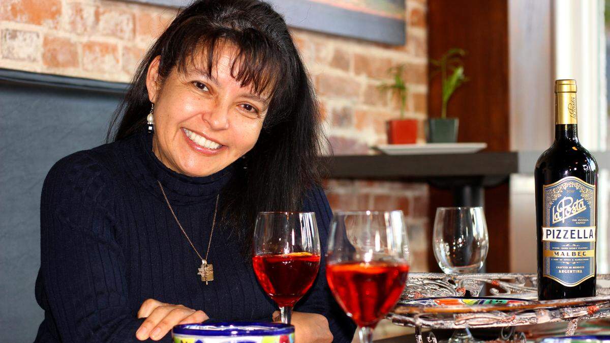 Founder of Sabor Latino, Fanny Ruiz de Chavez enjoys a glass of Argentinean wine in the comfort of her restaurant.