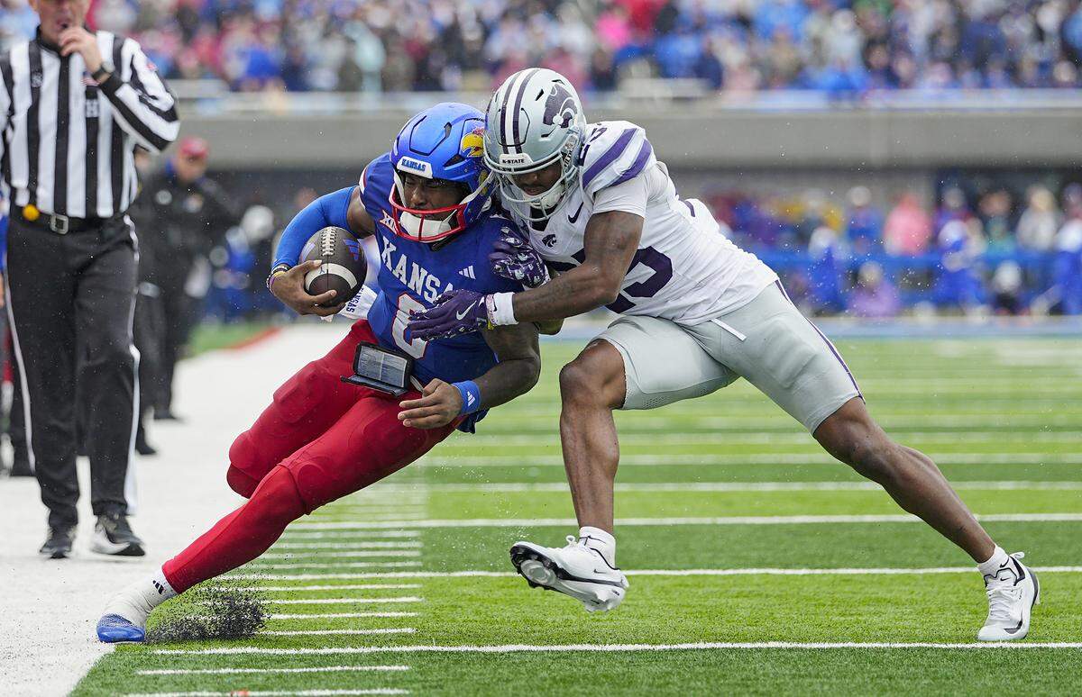 Jalon Daniels #6 of the Kansas Jayhawks runs the ball against Zashon Rich #25 of the Kansas State Wildcats during the first half at David Booth Kansas Memorial Stadium on October 25, 2025 in Lawrence, Kansas.