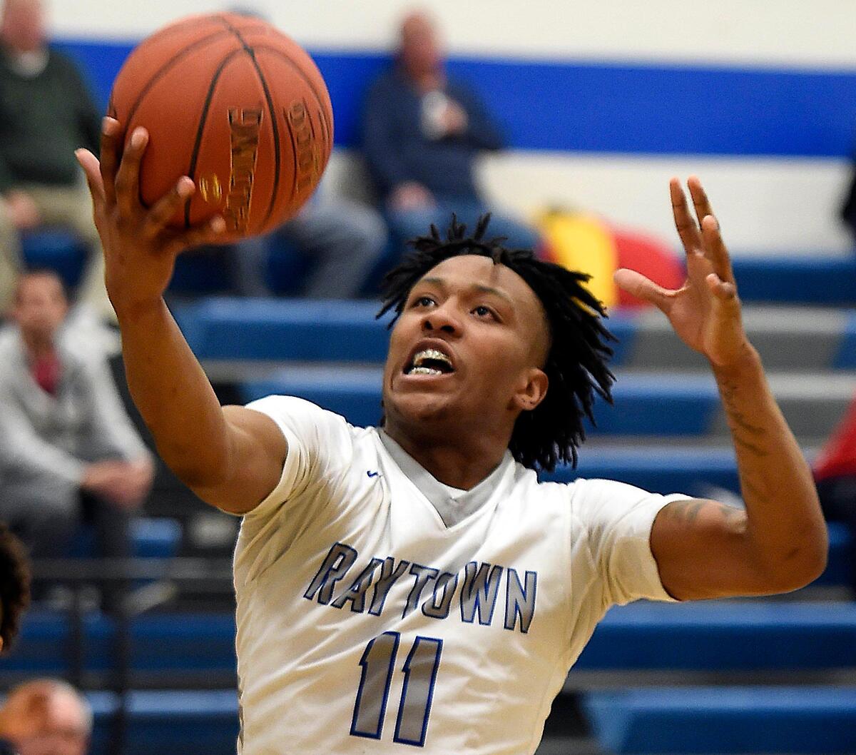 Desmond Hutson, a senior at Raytown High School, grabs a rebound during the team’s last home game of the season against William Chrisman. Desomond’s brother, Christopher Hutson Jr., was shot and killed two years ago, but his heart beats on in the body of Gary Dixon, who joins the Hutson family to watch Desmond’s games.