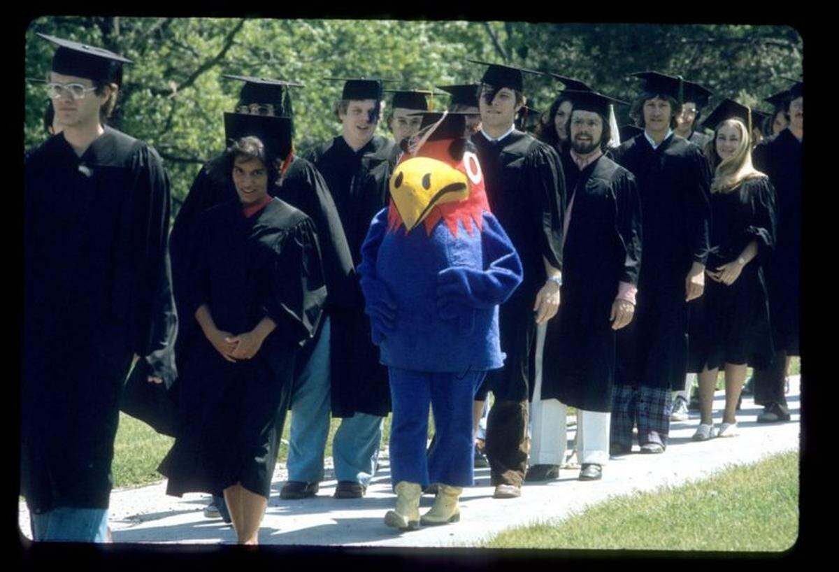 University of Kansas students and Baby Jay walk down the hill at KU commencement in 1974, a banner year for streaking at college campuses nationwide. Two KU students streaked at graduation.