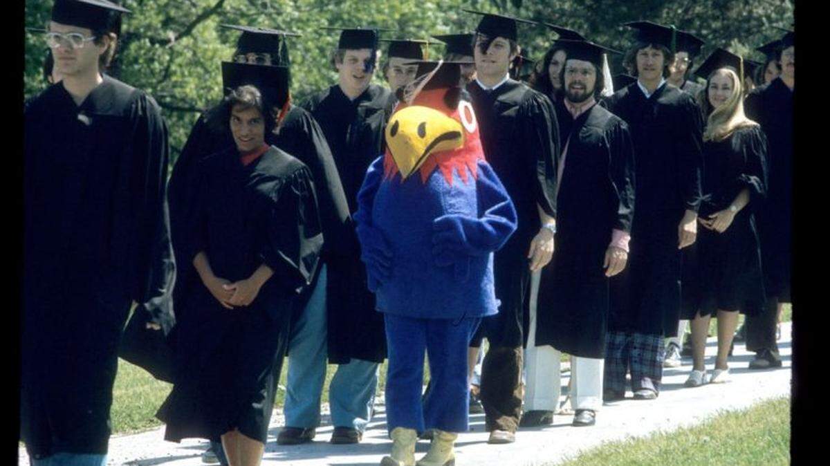 University of Kansas students and Baby Jay walk down the hill at KU commencement in 1974, a banner year for streaking at college campuses nationwide. Two KU students streaked at graduation.