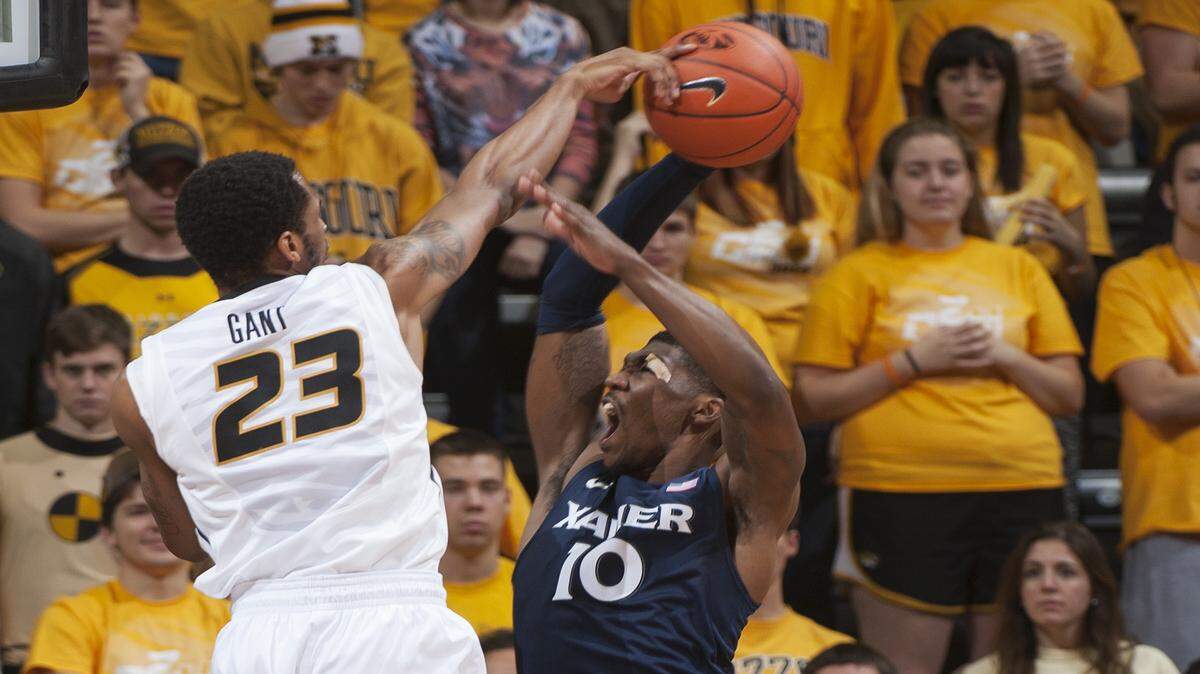 Missouri's Jakeenan Gant, left, blocks the shot of Xavier's Remy Abell, right, in front of teammate Montaque Gill-Caesar during the first half of an NCAA college basketball game Saturday, Dec. 13, 2014, in Columbia, Mo. 