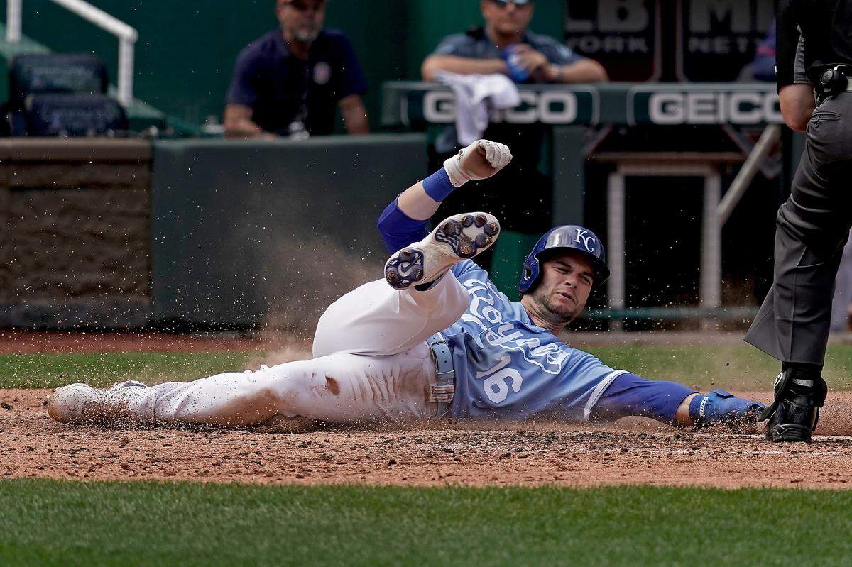 Kansas City Royals’ Andrew Benintendi slides after being tagged out at home as he tried to score on a fly out hit by Salvador Perez during the fourth inning of a baseball game against the Minnesota Twins Thursday, April 21, 2022, in Kansas City, Mo. (AP Photo/Charlie Riedel)