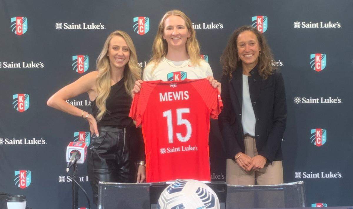 Flanked by co-owners Brittany Matthews, left, and Angie Long, right, newly acquired soccer superstar Sam Mewis showed off her Kansas City Current jersey.