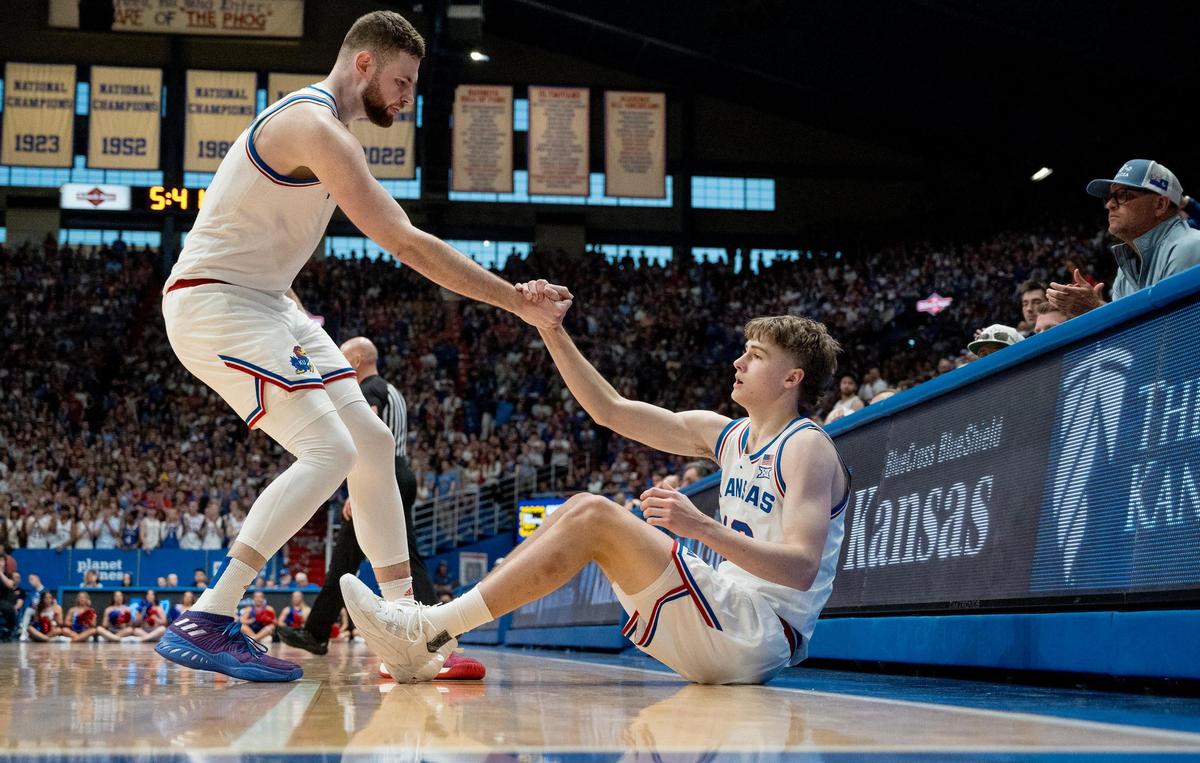 Kansas Jayhawks guard Johnny Furphy (10) is picked up by a teammate, center Hunter Dickinson, during an NCAA college basketball game against the Texas Longhorns on Saturday, Feb. 24, 2024, in Lawrence.