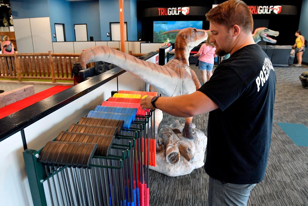 Nolan Ellis, a co-manager at the newly opened Prehistoric Putt in Independence, organizes a variety of putters for children and adults.