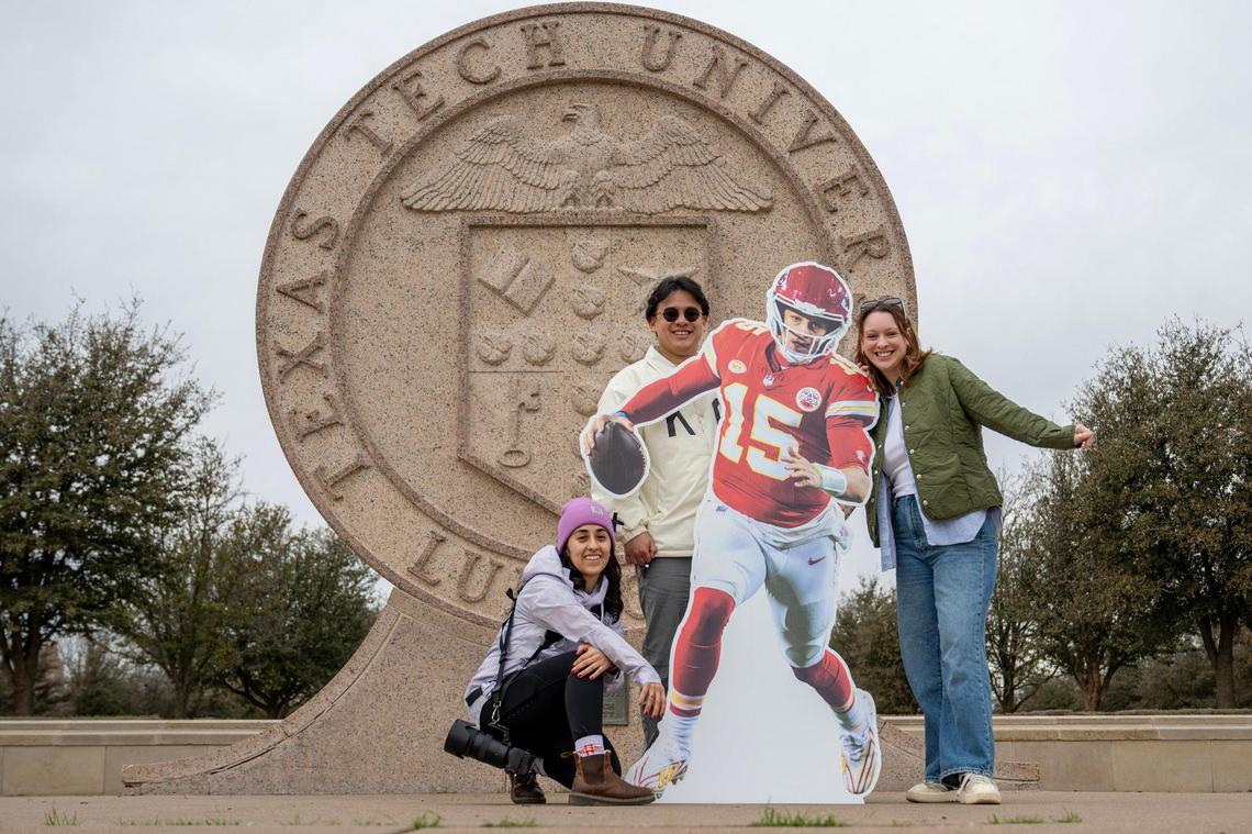 Journalists Emily Curiel, left, Irvin Zhang, and Alison Booth pose for a photo in front of the Texas Tech seal statue alongside a life-size cutout featuring Kansas City Chiefs quarterback Patrick Mahomes at Texas Tech University on Tuesday, Feb. 6, 2024, in Lubbock, Texas. The three are on The Kansas City Star Kingdom Road Trip en route to Super Bowl LVIII in Las Vegas.