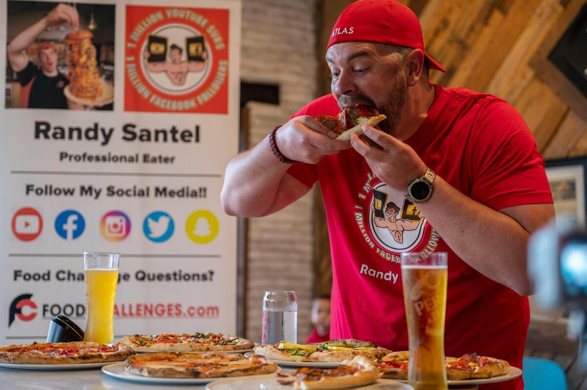 Randy Santel, a professional eater, eats six pizzas in about 30 minutes at 1889 Pizza Napoletana in Kansas City, Kan., on Wednesday, May 25, 2022.