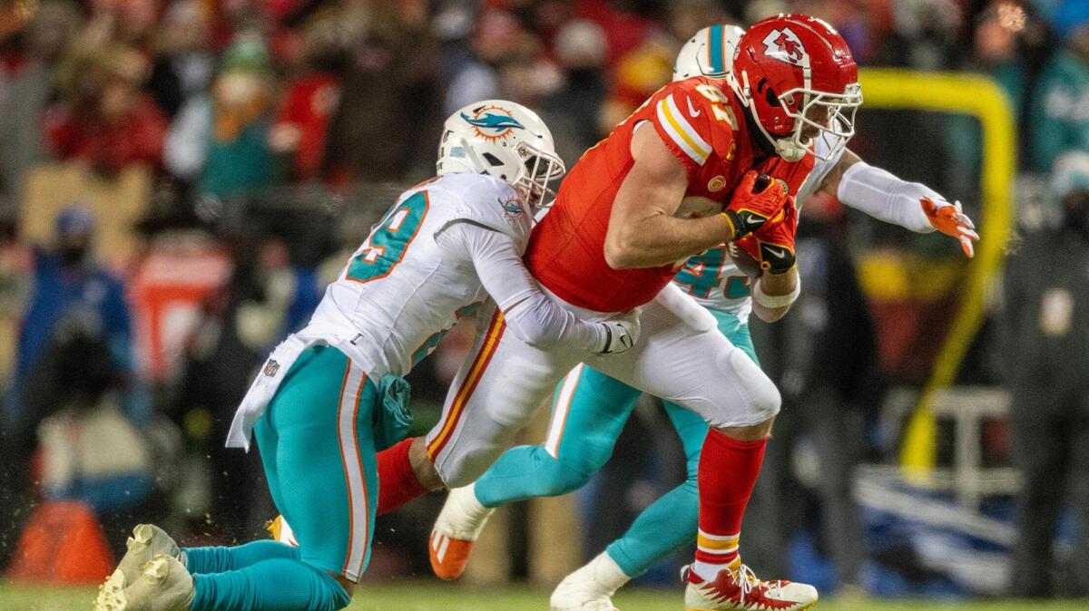 Kansas City Chiefs tight end Travis Kelce (87) is tackled by Miami Dolphins safety Brandon Jones (29) in the second quarter during an AFC Wild Card game on Saturday, Jan. 13, 2024, in Kansas City.