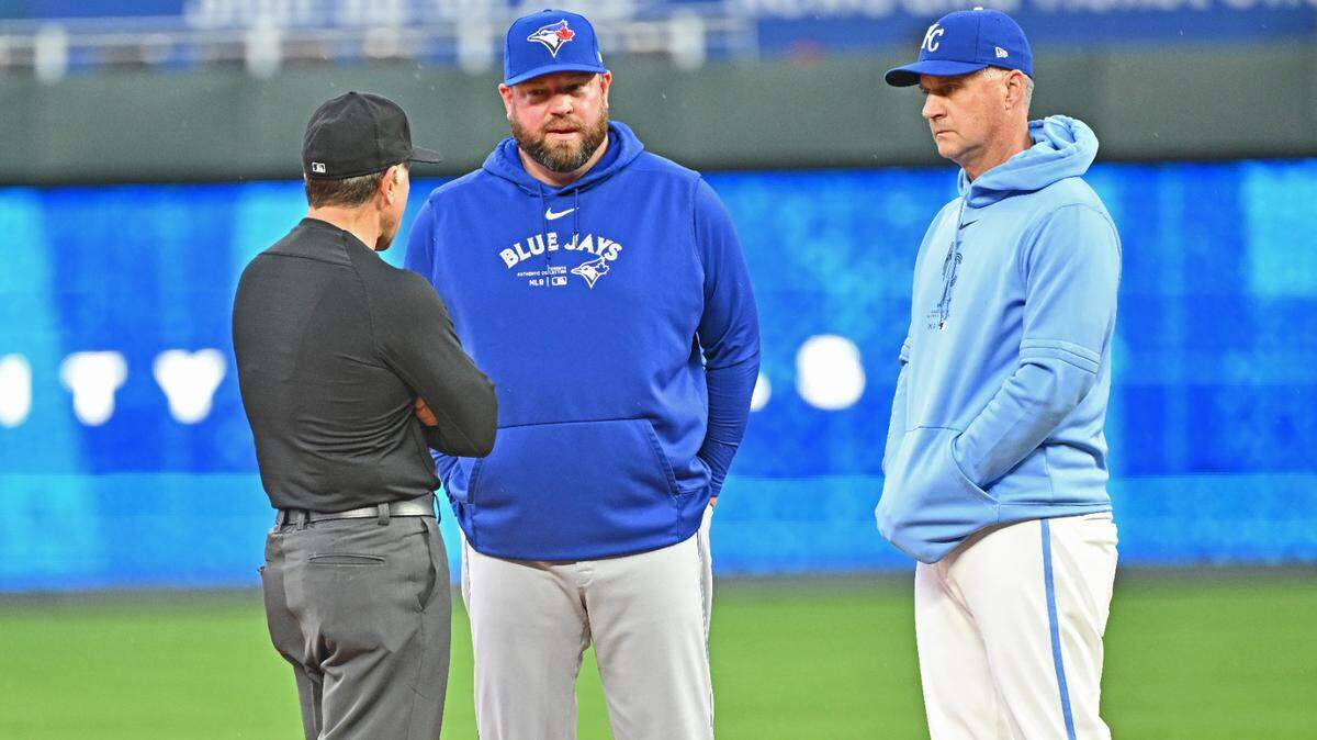 Apr 25, 2024; Kansas City, Missouri, USA; Kansas City Royals manager Matt Quatraro (right), Toronto Blue Jays manager John Schneider (center) and umpire crew chief Chris Guccione (left) talk about the field conditions, after the rain delay at Kauffman Stadium. Mandatory Credit: Peter Aiken-USA TODAY Sports