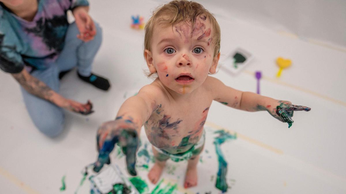 One-year-old William Pyne covers himself in paint during the baby paint crawl at Science City in Union Station on Thursday, April 6, 2023, in Kansas City. The Engineerium was transformed into a blank canvas where babies and toddlers were allowed to strip down to their diapers and explore their senses with non-toxic paint.