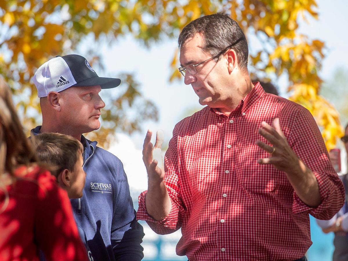 Kansas Attorney General and GOP nominee for governor Derek Schmidt, right, talks with Secretary of State Scott Schwab, Sunday, October 9, 2022, during a GOP bus tour campaign stop at Shawnee Mission Park.