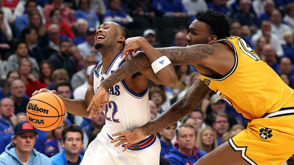 Darryn Peterson #22 of the Kansas Jayhawks is fouled by Shawn Phillips Jr. #15 of the Missouri Tigers during the game at T-Mobile Center on December 7, 2025 in Kansas City.