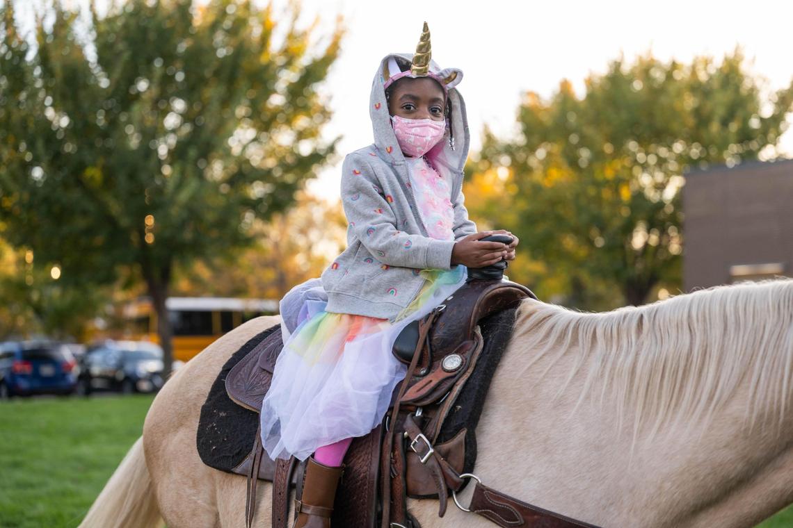 A young child rides ‘Goldie’ during a “trunk or treat” event on Kansas City’s East Side in October 2024.