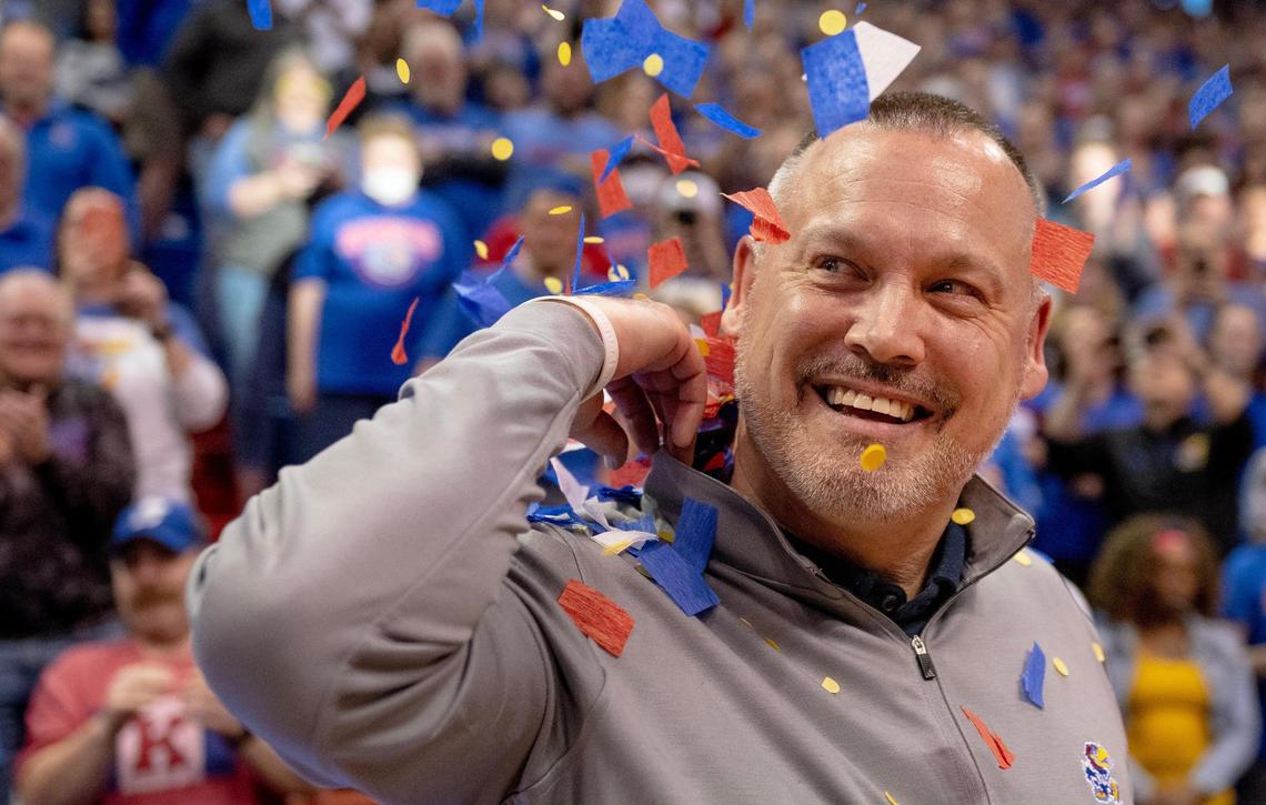 Kansas head coach Brandon Schneider smiles after being showered in confetti after defeating Columbia 66-59 in an NCAA college basketball game in the final of the WNIT, Saturday, April 1, 2023, in Lawrence, Kan.