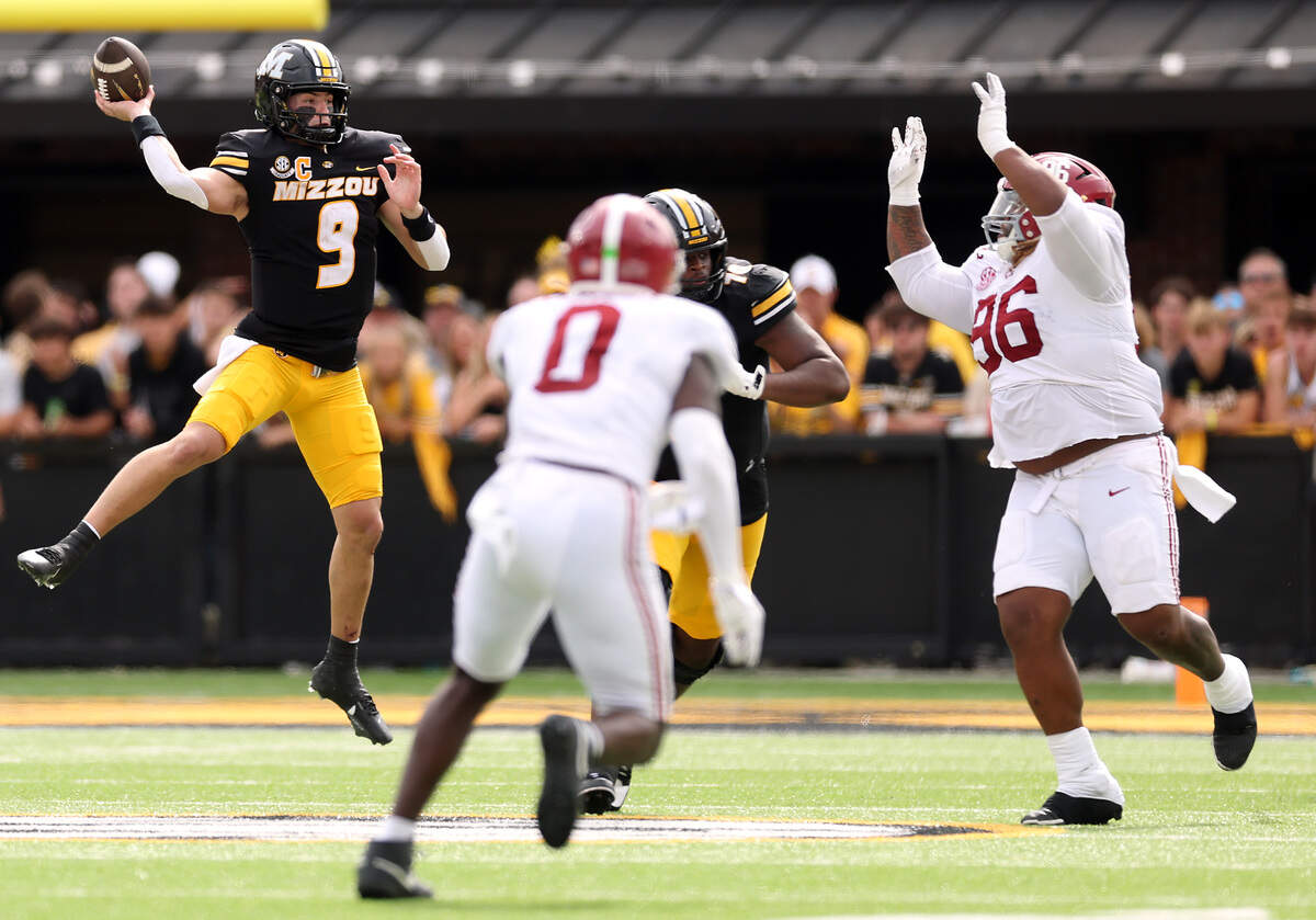 Quarterback Beau Pribula #9 of the Missouri Tigers passes as Tim Keenan III #96 and Deontae Lawson #0 of the Alabama Crimson Tide defend during the game at Faurot Field at Memorial Stadium on October 11, 2025 in Columbia.