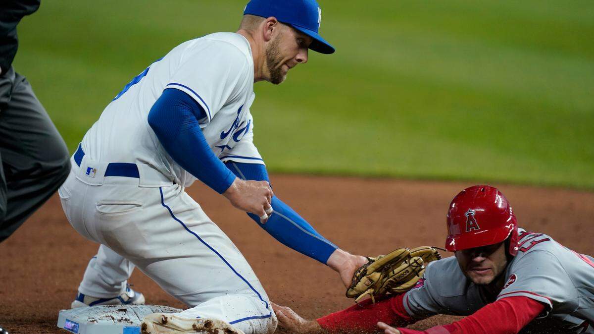 Los Angeles Angels David Fletcher, right, is tagged out by Kansas City Royals third baseman Hunter Dozier, left, during the ninth inning of a baseball game at Kauffman Stadium in Kansas City, Mo., Tuesday, April 13, 2021. The Royals defeated the Angels 3-2. (AP Photo/Orlin Wagner)