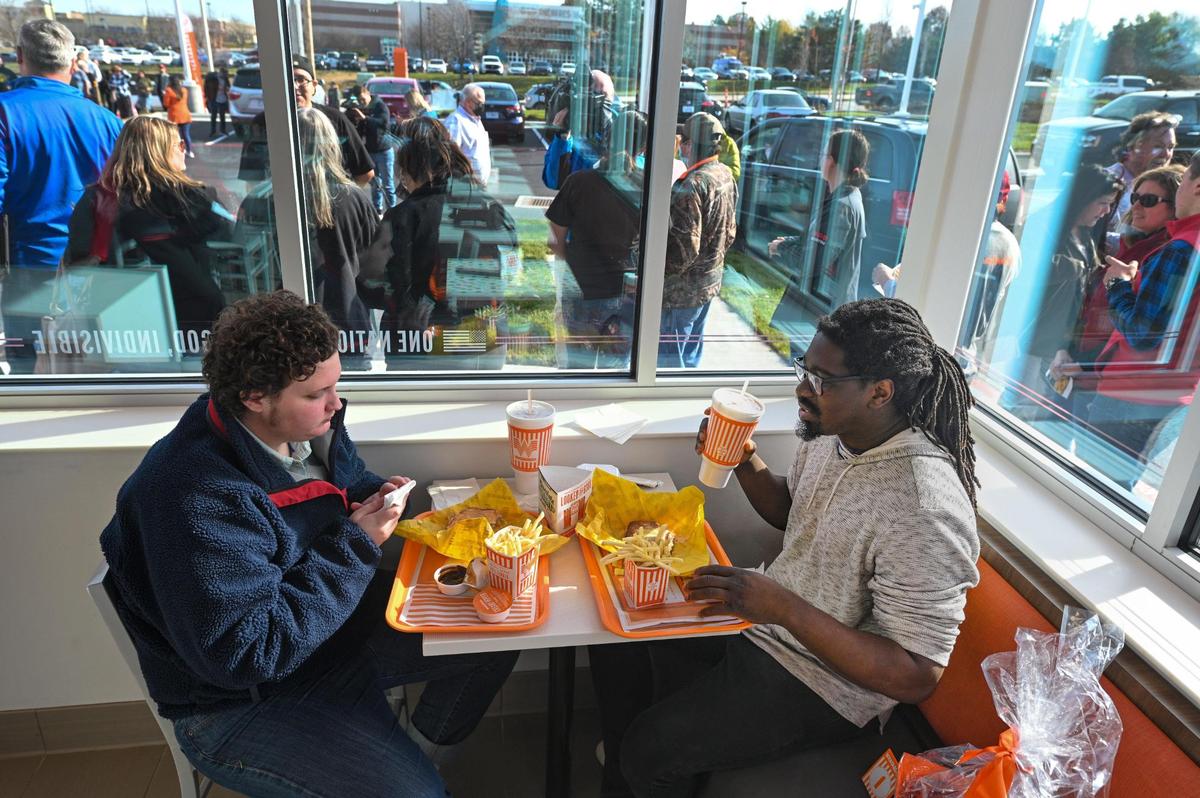 Customers waited in line Monnday to get in as Matt Ford, right, of Prairie Village, and Wesley Harden of Fairway were the first to place orders at the new Whataburger in Lee’s Summit. Ford, a Whataburger fanatic, received a gift basket which includes 52 Whataburgers. Harden, a first-timer, said he “loved it.”