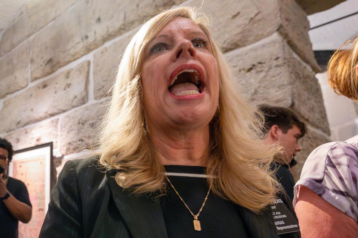 State Rep. Angela Stiens recites a Hail Mary as Satanic Grotto Black Mass participants walk through the hallway of the Kansas State Capitol on Friday, March 28, 2025, in Topeka.