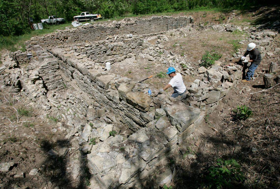 Tim Eastwood (left) and Brent Freeman, both with Hoffman Cortes Restoration, cleaned out mortar joints on Monday, May 9, 2005, at the Quindaro ruins in Kansas City, Kan. The men were working on the Otis Webb building. In the background are the foundations of the Jacob Henry building and the Wyandott House hotel. Once clean, the joints will be tuckpointed.