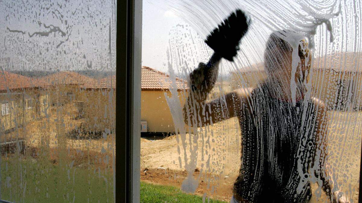 A woman cleans her windows. (Photo credit should read GALI TIBBON/AFP via Getty Images)