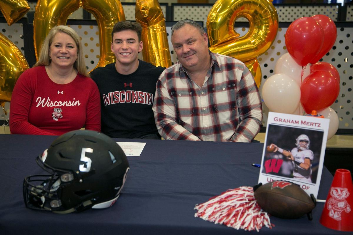 Graham Mertz, of Blue Valley North, the top high school football player in KC officially signed with Wisconsin Wednesday, December 19, 2019 at Blue Valley North. After the ceremony Graham posed with his parents Ron and Amy Mertz for family photos.