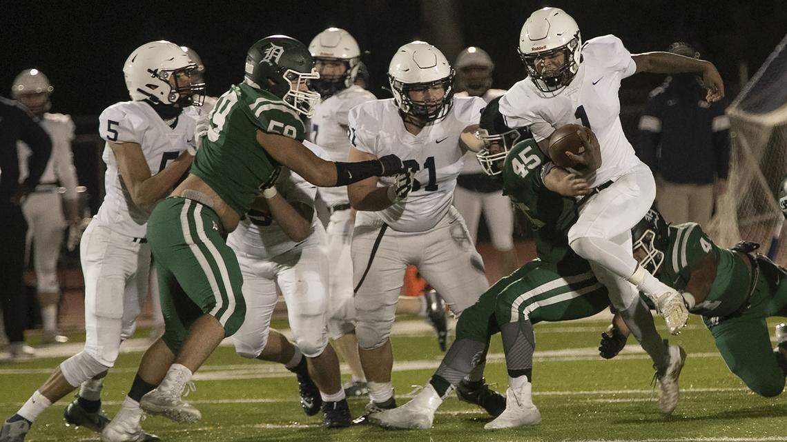 Mill Valley’s Quin Wittenauer, right (No. 1) looks for a hole in the Wildcats’ defense during Friday night’s Kansas high school playoff game at DeSoto.