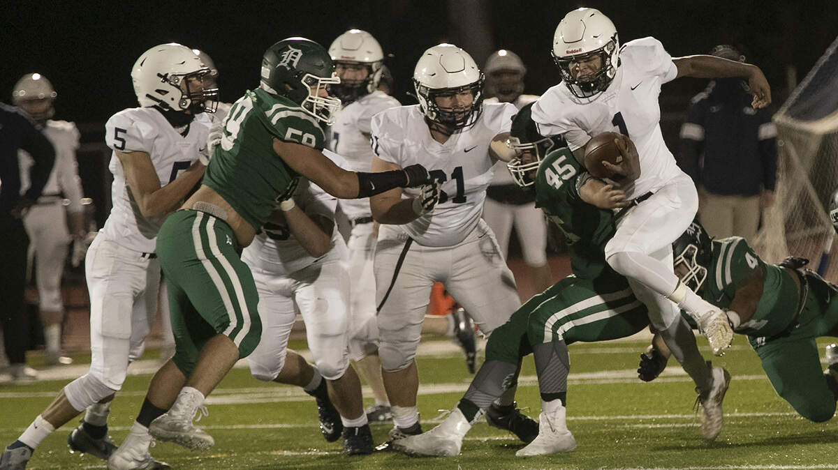 Mill Valley’s Quin Wittenauer, right (No. 1) looks for a hole in the Wildcats’ defense during Friday night’s Kansas high school playoff game at DeSoto.