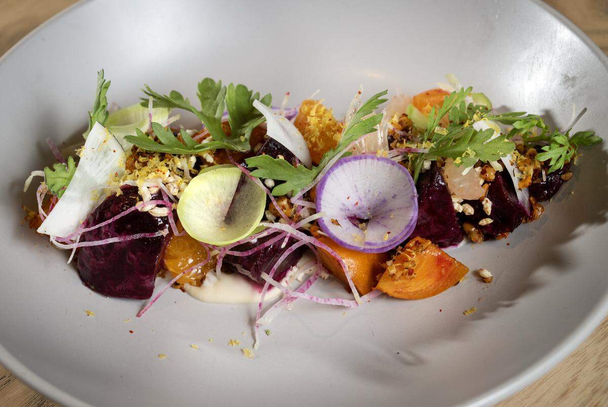 The Beet salad featuring koji tofu puree, seaweed spiced walnuts, miso dressing, tangerine, watermelon radish, puffed rice, chrysanthemum, and grated cured egg yolk at Anjin, a 20-seat Japanese Izakayas-style restaurant, on Monday, March 16, 2026, in Kansas City.