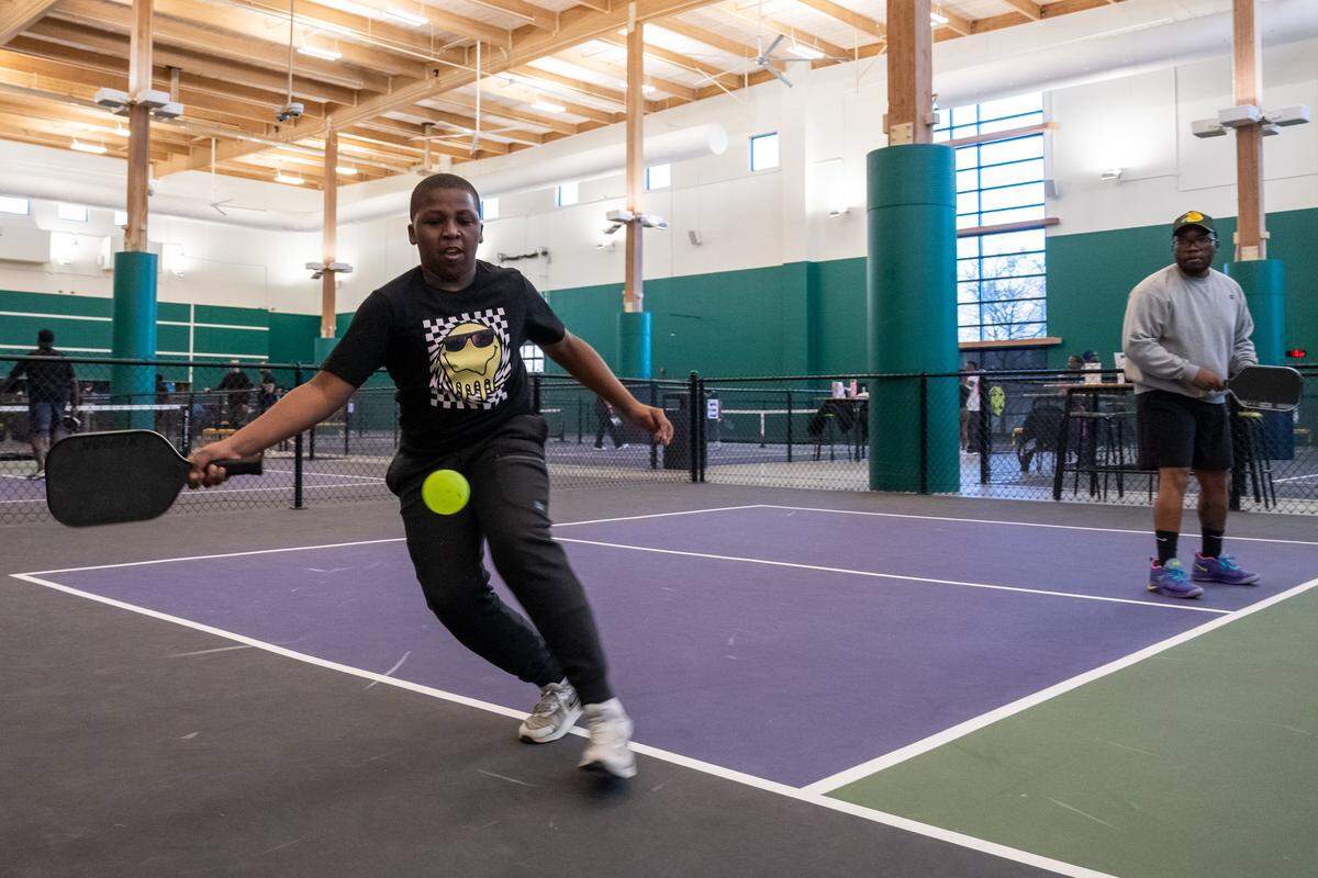 Ayden Campbell, 11, takes a swing at a wiffleball during a meeting of the Black Pickleball Club at SW19 at the Stadium, on Sunday, February 22, 2026, in Kansas City. The club, started by Brandan Jackson, hosts weekly meetups every Sunday as a space for Black people to participate in pickleball.