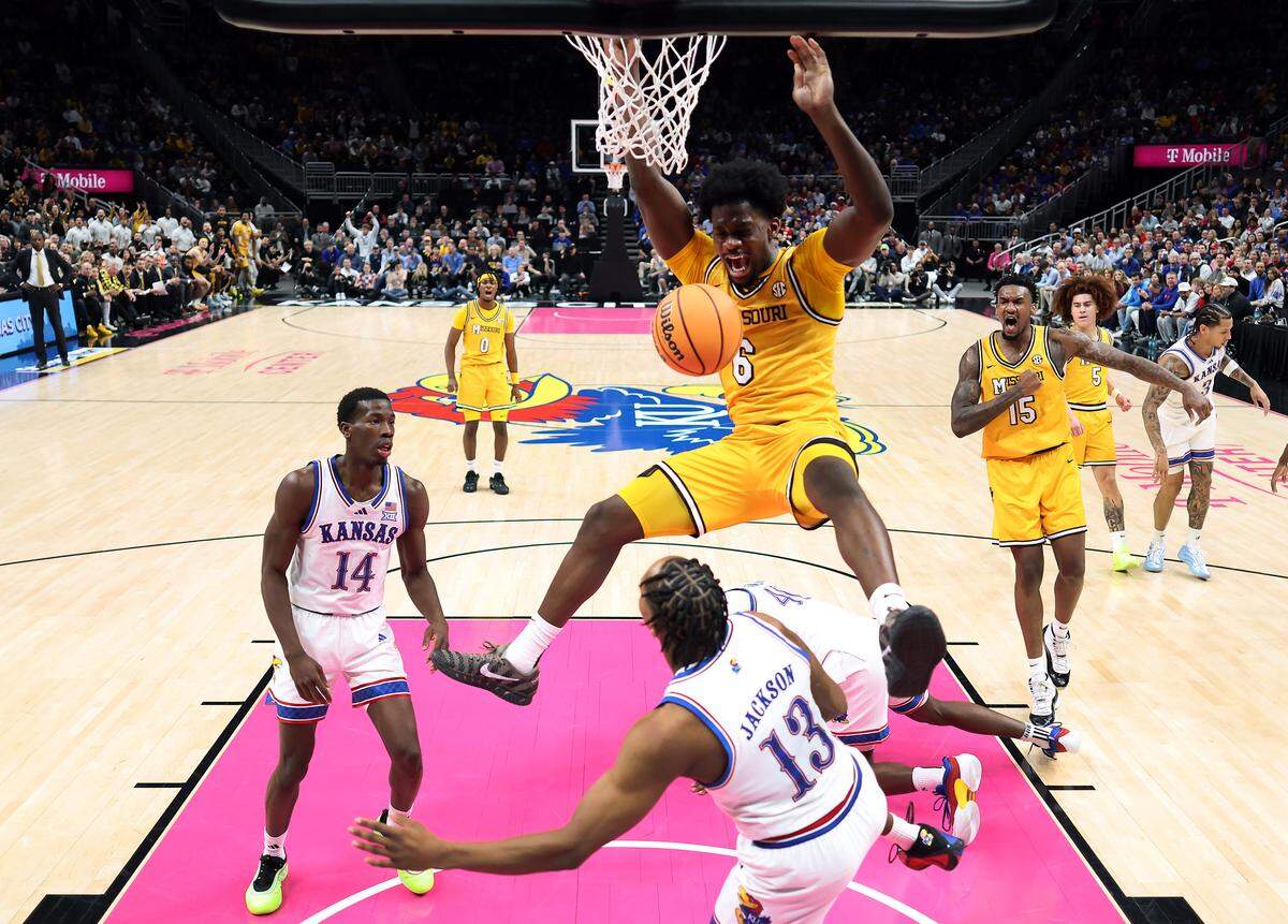 Annor Boateng #6 of the Missouri Tigers dunks as Tre White #3, Melvin Council Jr. #14 and Flory Bidunga #40 of the Kansas Jayhawks look on during the game at T-Mobile Center on December 7, 2025 in Kansas City, Missouri.