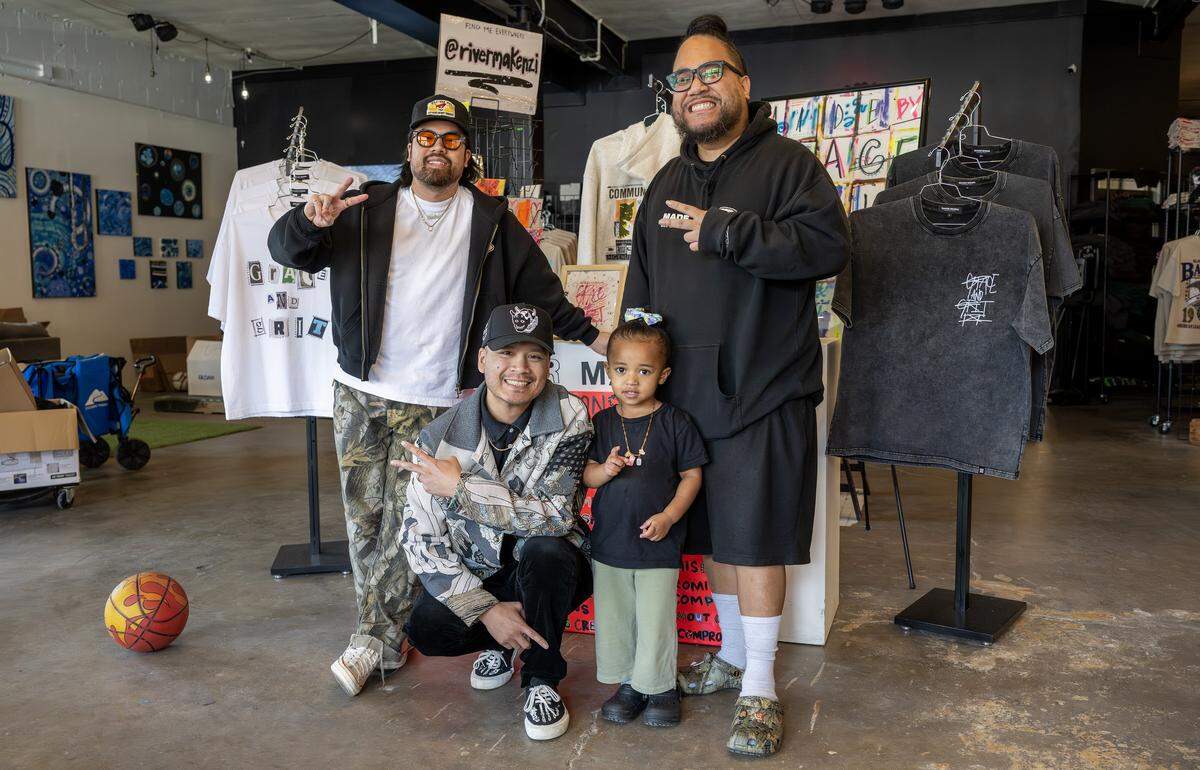 Vu Radley, left, Jesse Phouangphet and Mark Launiu, owners of Made Mobb, pose for a portrait with Launiu's daughter on Wednesday, March 18, 2026, in Kansas City.