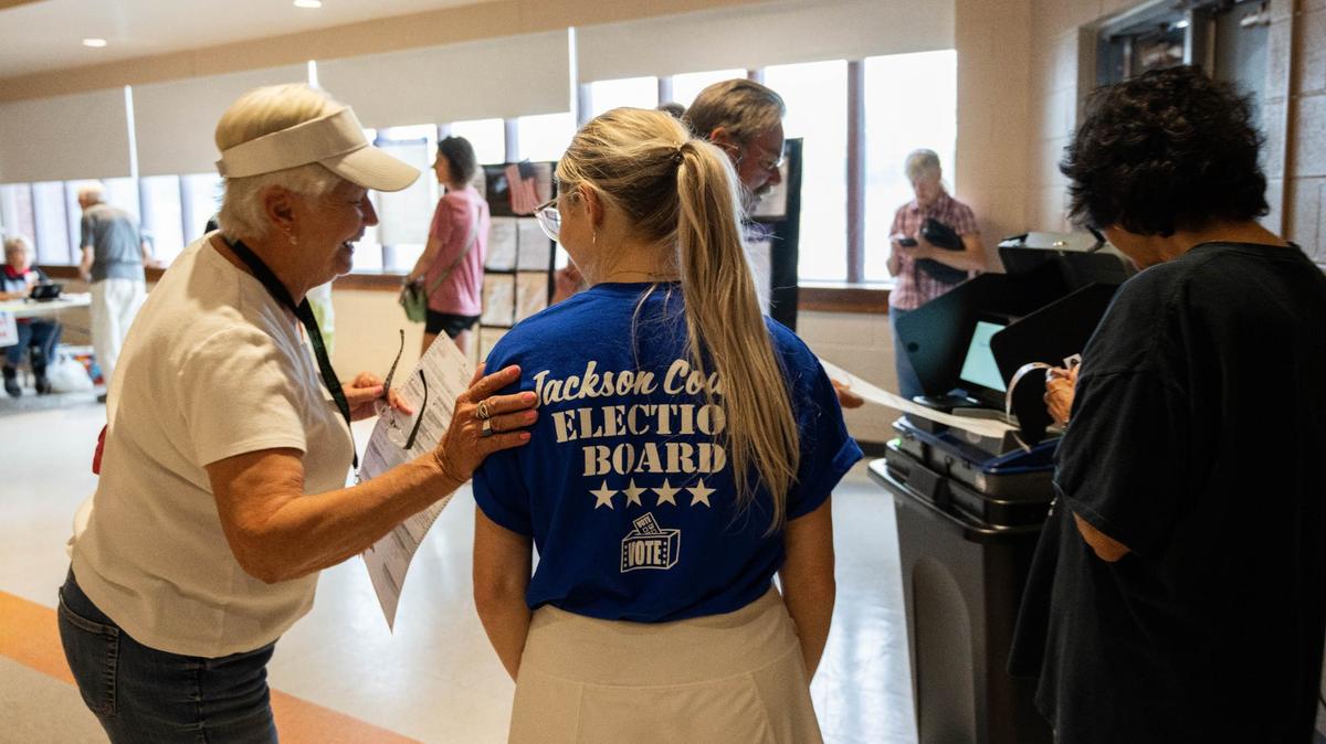 Poll worker Natalie Taylor helps voters with their ballots for the primary election at the Lees Summit Christian Church in August in Lee’s Summit.