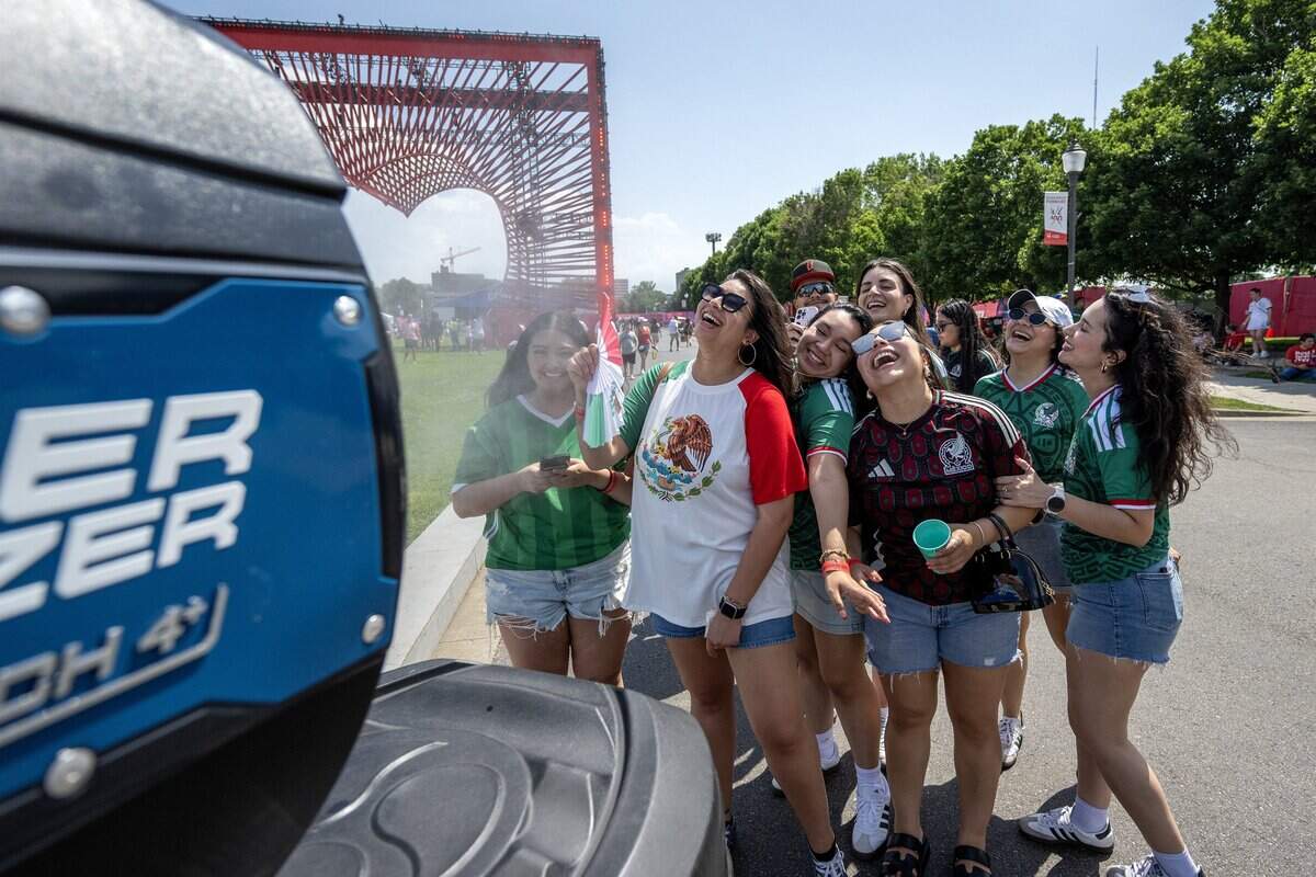 Mexico fans laugh as they stand near a large mister while attending at the FIFA Fan Festival on Thursday, June 11, 2026, in Kansas City.