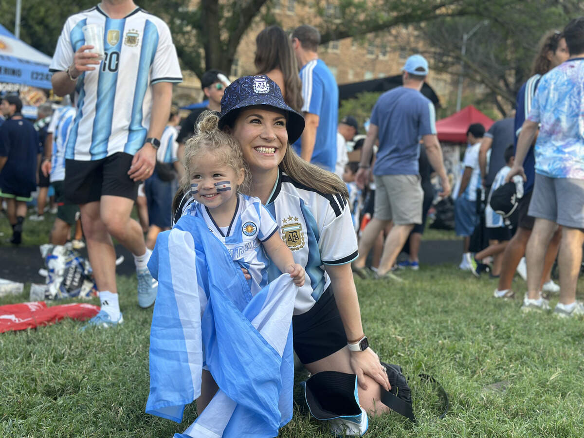 Olivia Schneider poses with her daughter, Charlotte, for a photo during the banderazo in Mill Creek Park on July 10. Schneider has lived in Kansas City for five years, and was excited to connect with her roots as Argentina claimed Kansas City as its host city.