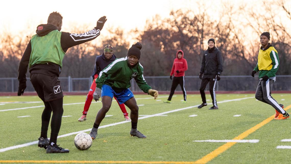 East High School forward Donat Ekengya, center left, defends during a practice on Thursday, Nov. 17, 2022 in Kansas City.