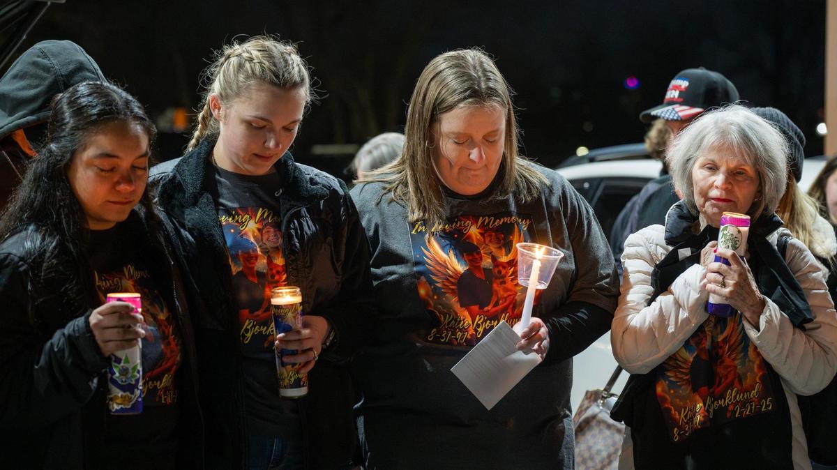 Jamie Bishop, center, along with other coworkers of Katherine Bjorklund and her grandmother, Shannon Younghanz, take a moment of silence during a candlelight vigil for Katherine on Thursday, March 6, 2025, in Kansas City.