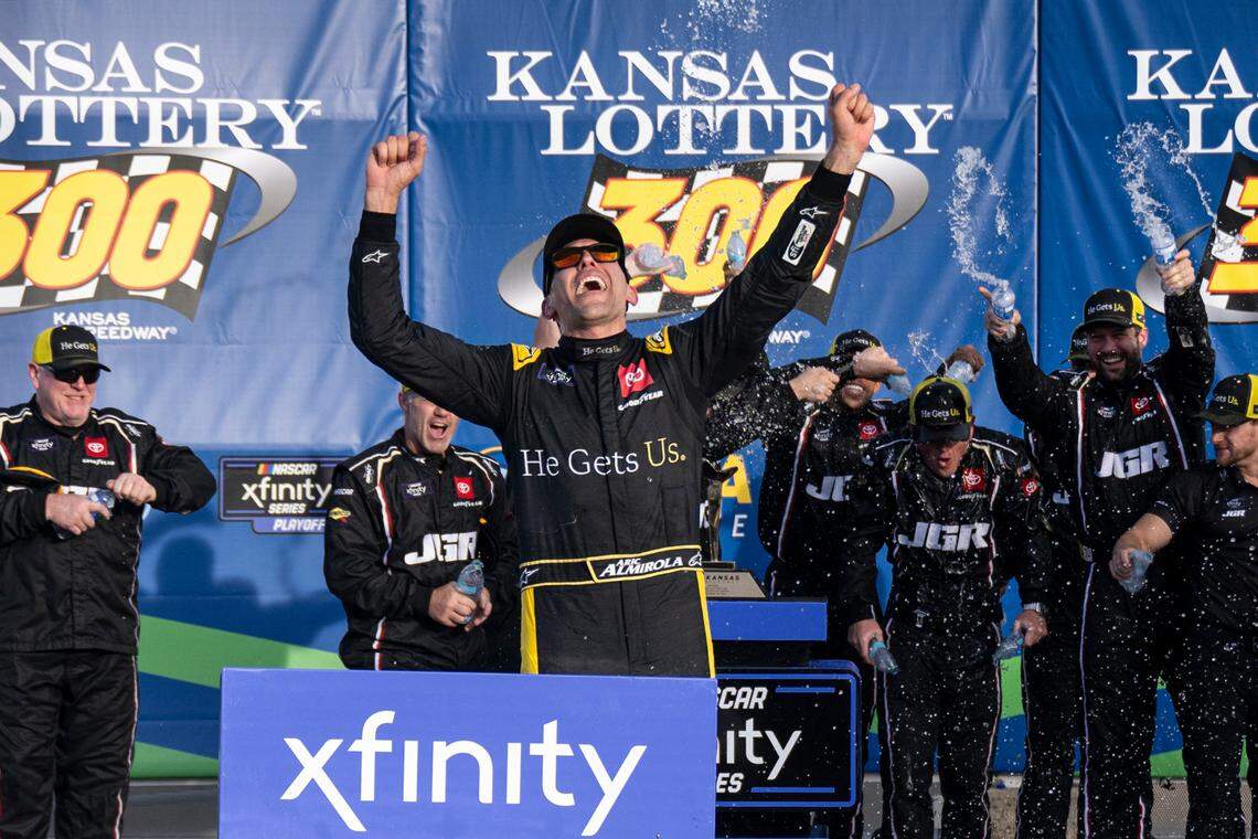 Xfinity Series driver Aric Almirola celebrates in Victory Lane with his team after winning the NASCAR Xfinity Series playoff race on Saturday at Kansas Speedway in Kansas City, Kan.