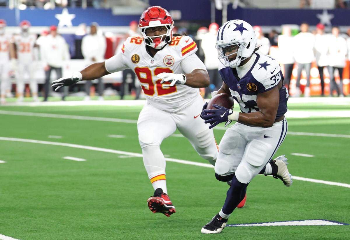 Javonte Williams of the Dallas Cowboys, right, carries the ball as Kansas City Chiefs defensive lineman Derrick Nnadi closes in during an NFL Week 13 Thanksgiving Day game at AT&T Stadium in Arlington, Texas on Thursday, Nov. 27, 2025.