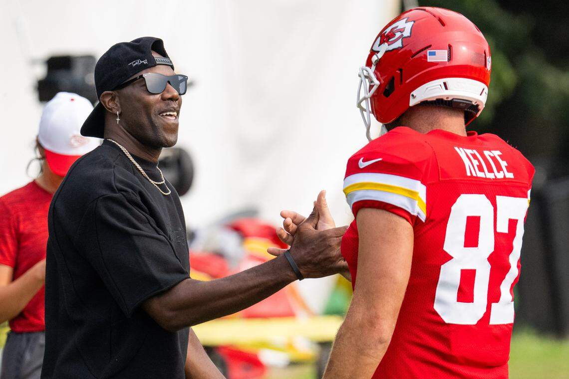 Former NFL wide receiver Terrell Owens shakes hands with Kansas City Chiefs tight end Travis Kelce (87) at Chiefs Training Camp on Thursday, Aug. 7, 2025 in St. Joseph. Owens, who played for head coach Andy Reid when he coached the Philadelphia Eagles, attended training camp and interacted with several players and coaches.