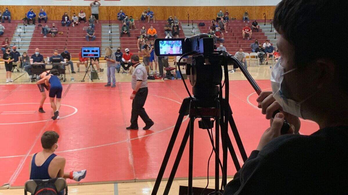 Evan Bowlin runs the camera during a wrestling match at Bernard Campbell Middle School.