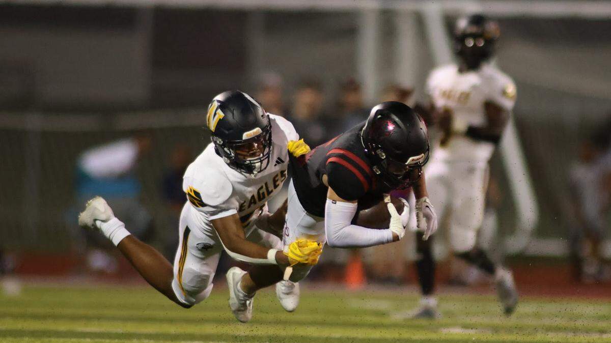Lee’s Summit North’s Tanner Howes dives ahead for yardage against Liberty North on Friday night, the opening night for high school football around the metro.