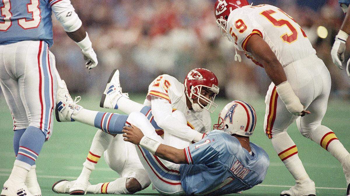 Houston Oilers’ Warren Moon (1) and Kansas City Chiefs’ Albert Lewis (29) look each other eye to eye after Moon was sacked in the first quarter of a 1994 playoff game.